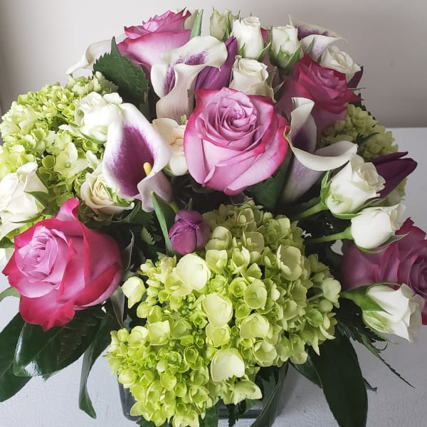 Bouquet of pink roses, white calla lilies, and green hydrangeas