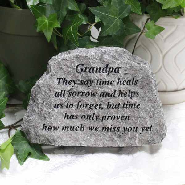 Engraved memorial stone with ivy leaves in the background