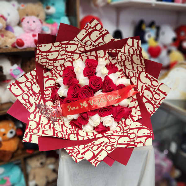 Bouquet of red and white roses wrapped in patterned paper