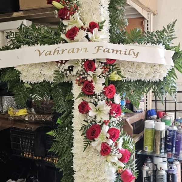 Large floral cross with red roses, white lilies, and white chrysanthemums
