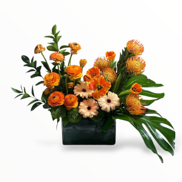 Orange and cream flowers arranged in a dark rectangular vase