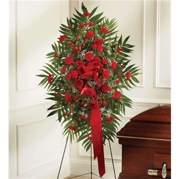 Standing red floral spray beside a casket