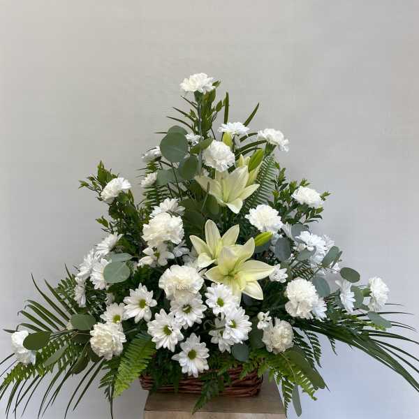 White lilies and daisies in a wicker basket arrangement