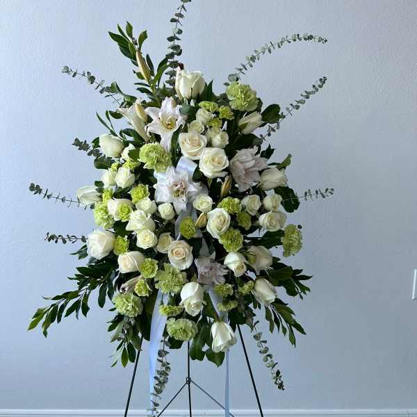 Standing floral spray of white roses and lilies with green accents