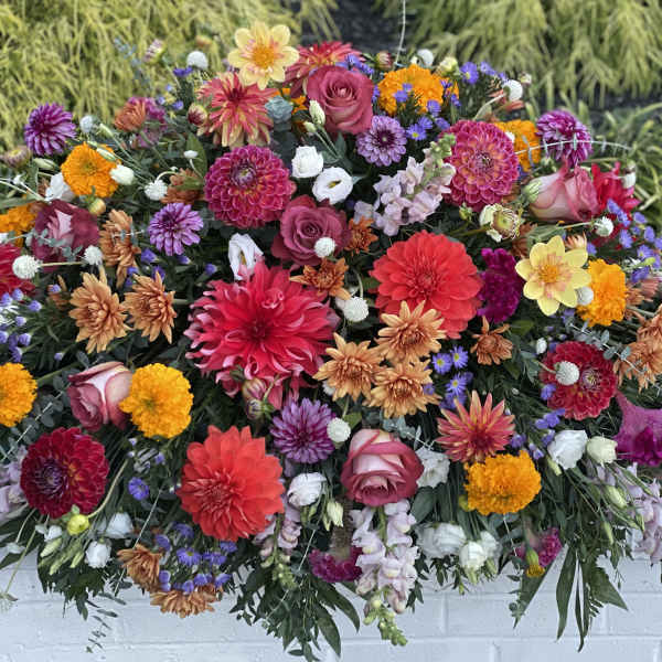Large colorful floral arrangement with dahlias, roses, and marigolds