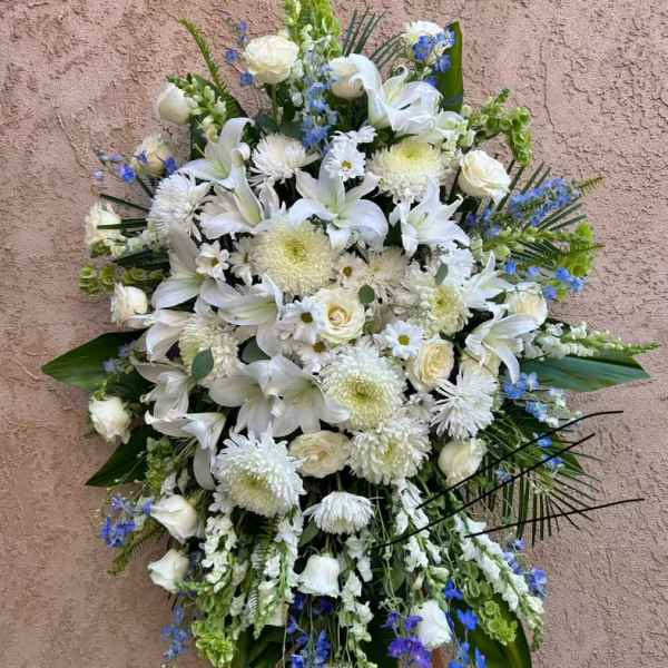Large white funeral spray with lilies and chrysanthemums