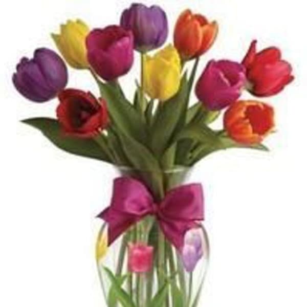 Colorful tulips in a clear glass vase with a pink bow