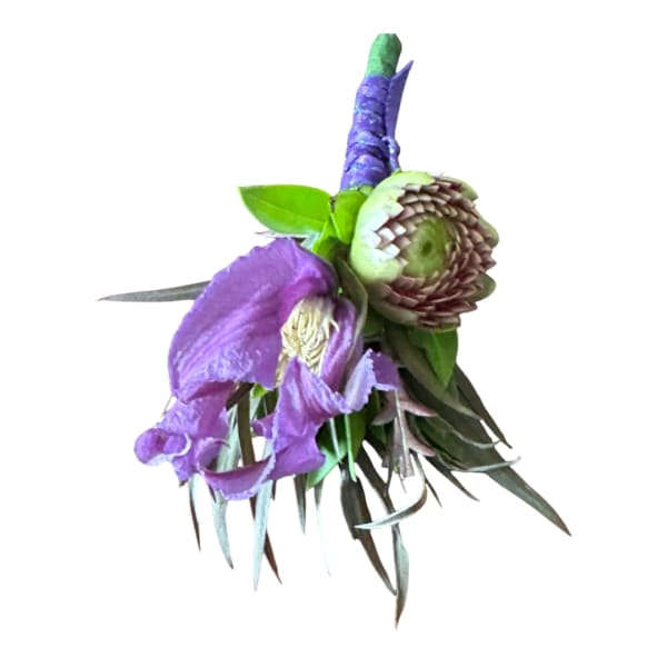 Purple orchid boutonniere with green succulent and leaves