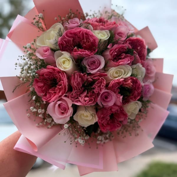 Pink and white rose bouquet wrapped in pale pink paper