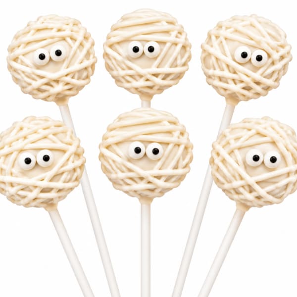 Five mummy-themed cake pops with candy eyes on white sticks