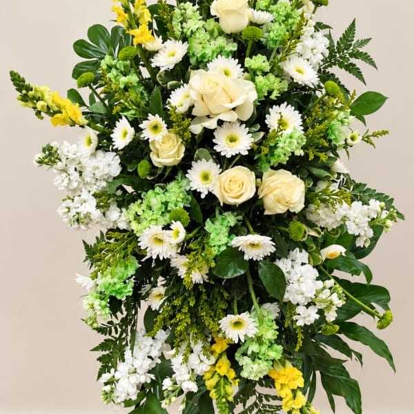 Tall floral arrangement with white roses, daisies, and green blooms