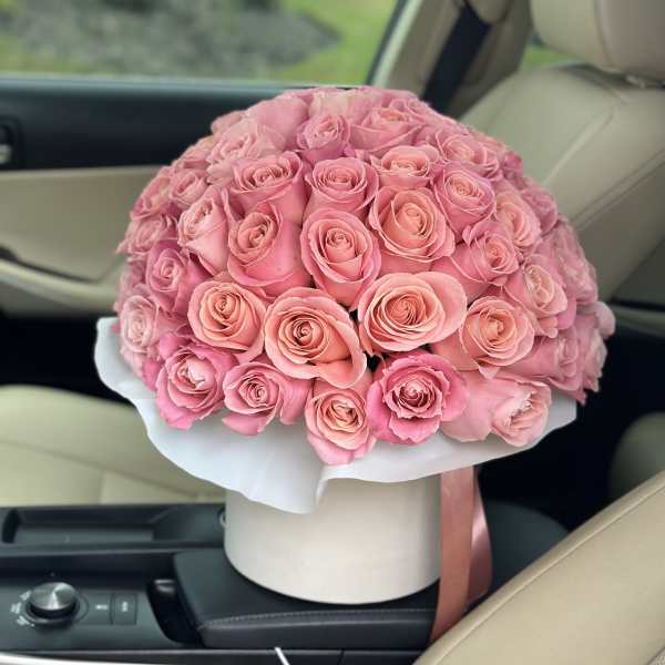 Round bouquet of pink roses in a white hat box
