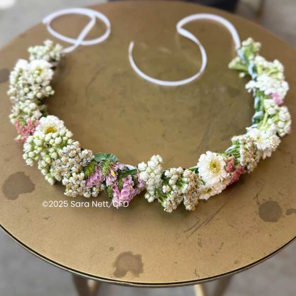 Floral crown with white and pink flowers on a round table