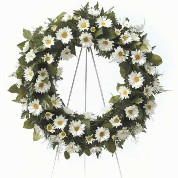 White daisy funeral wreath on a metal stand