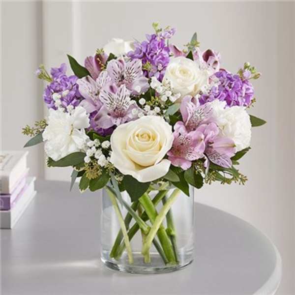 Bouquet of white and lavender flowers in a clear glass vase
