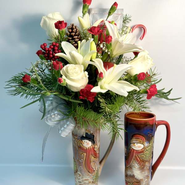 Holiday bouquet with white lilies, red carnations, and a pinecone in a decorative vase