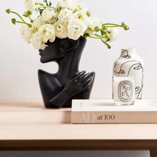 White ranunculus arrangement in a black sculptural vase