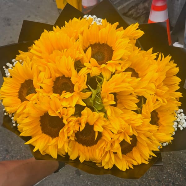 Bouquet of yellow sunflowers wrapped in dark paper