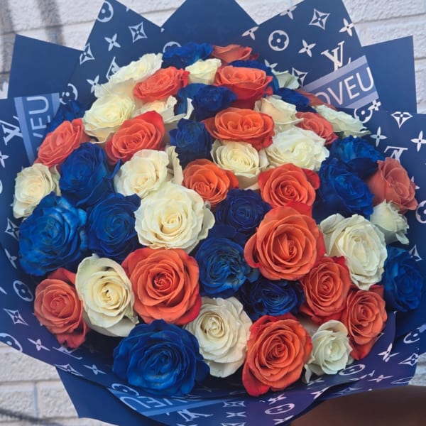Bouquet of blue, orange, and white roses wrapped in patterned paper