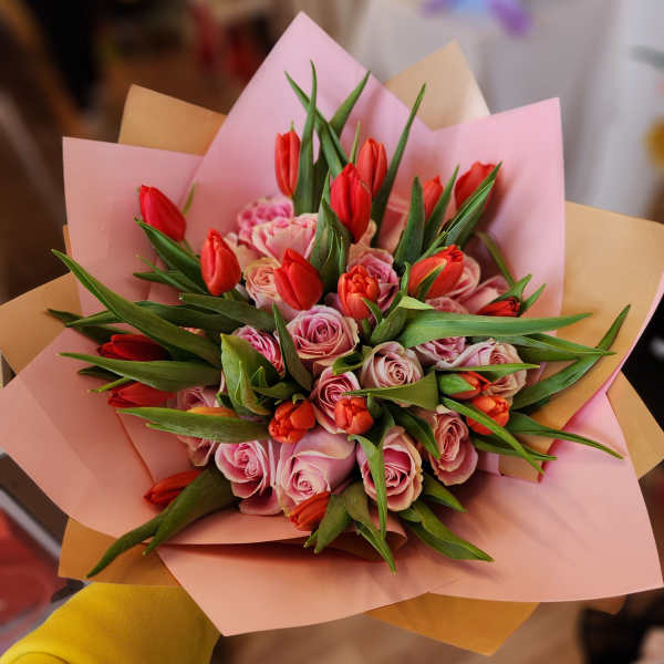 Pink roses and red tulips wrapped in pastel paper