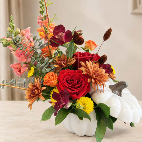 Mixed floral arrangement in a white pumpkin container