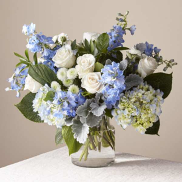 Blue and white flower arrangement in a clear glass vase