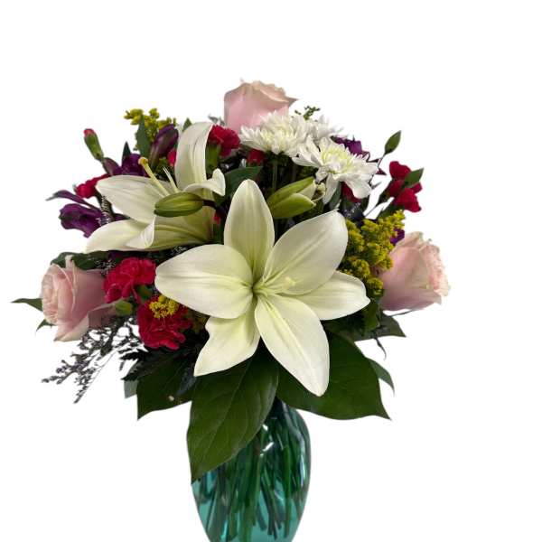 Bouquet of white lilies, pink roses, and mixed blooms in a blue glass vase