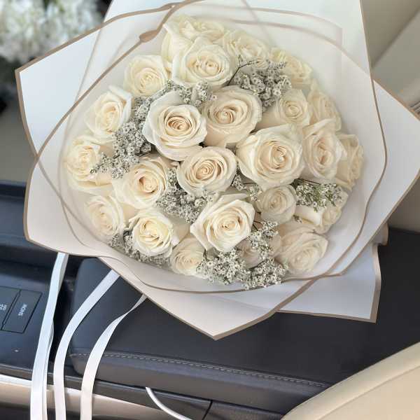 Bouquet of cream roses wrapped in white paper