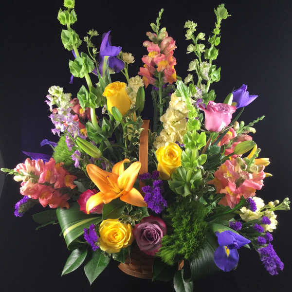 Colorful mixed flower arrangement in a basket with tall blooms