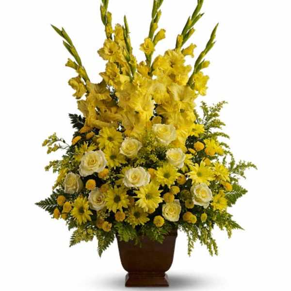 Tall yellow floral arrangement in a brown urn vase