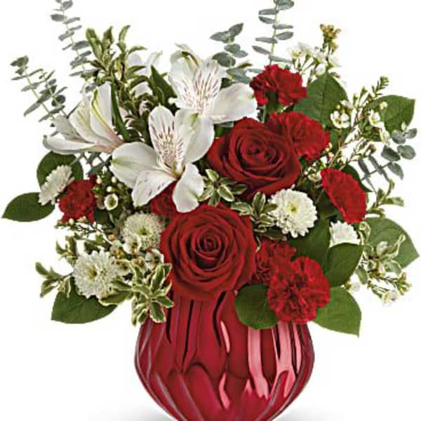 Red and white floral arrangement in a red vase