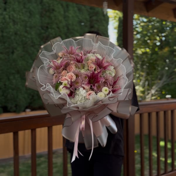 Large pink and white bouquet wrapped in translucent paper