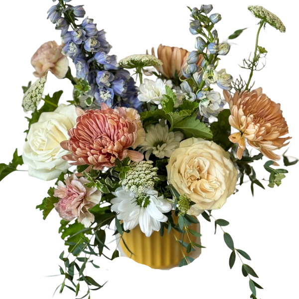 Mixed bouquet of roses, chrysanthemums, and blue delphinium in a yellow vase