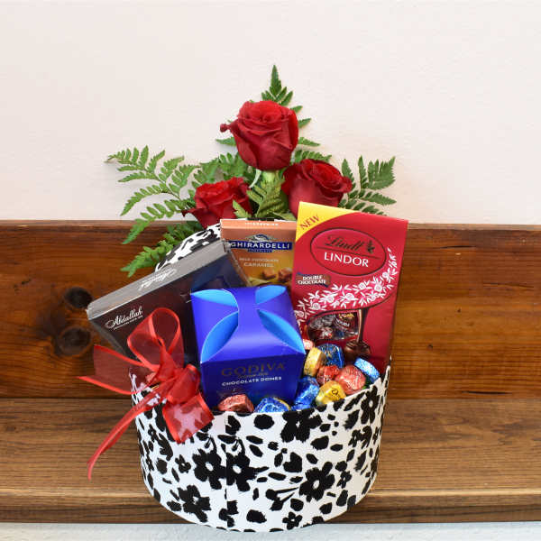 Red roses with assorted chocolates in a patterned gift box
