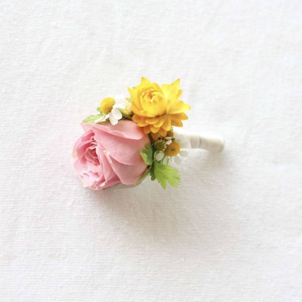 Pink and yellow floral boutonniere with a wrapped stem