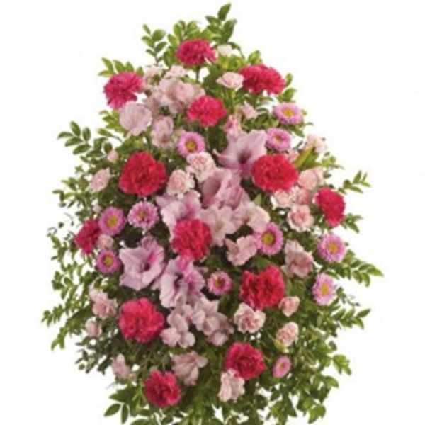 Standing spray of pink and red flowers with greenery