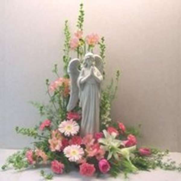 Angel statue surrounded by pink and white flowers in a floral display