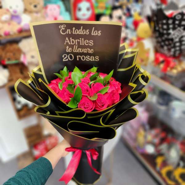 Bouquet of bright pink roses wrapped in black paper with a ribbon