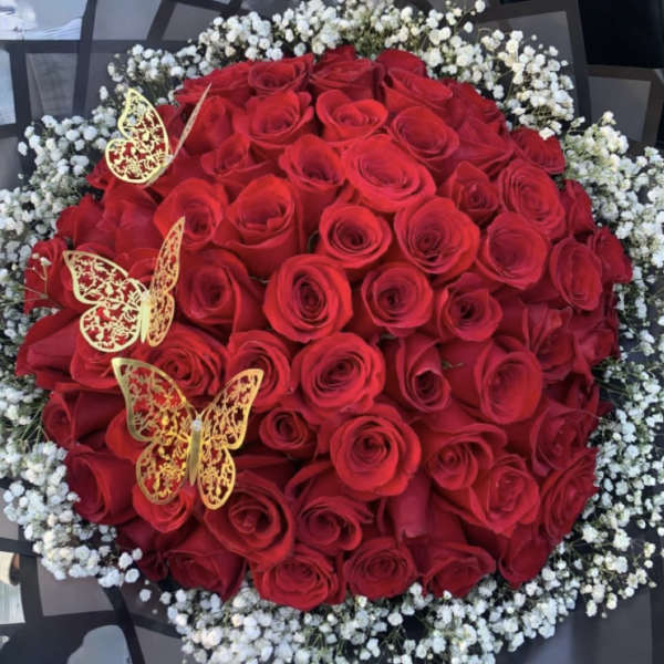 Round bouquet of red roses with white baby's breath and gold butterfly accents