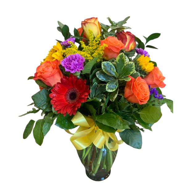 Mixed bouquet of roses, gerbera daisies, and carnations in a glass vase