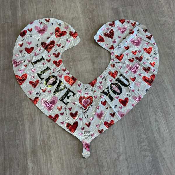 Heart-shaped foil balloon with "I LOVE YOU" text on a wood floor