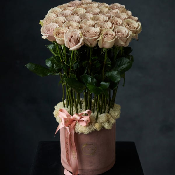 Round bouquet of pale pink roses in a pink hatbox with a ribbon