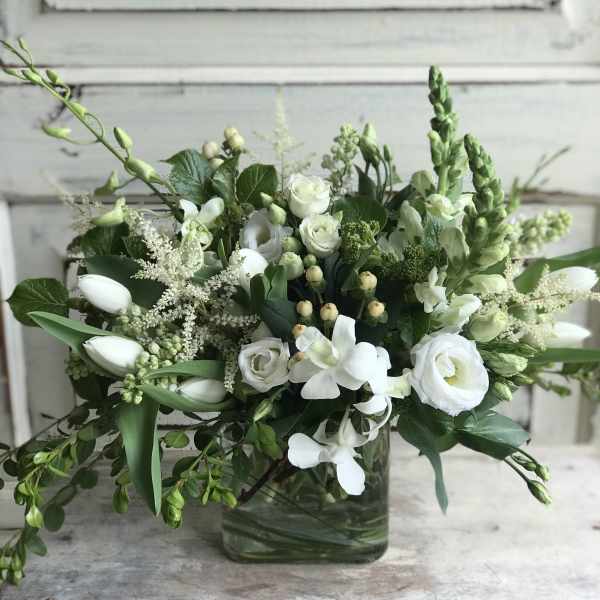 White floral arrangement in a square glass vase