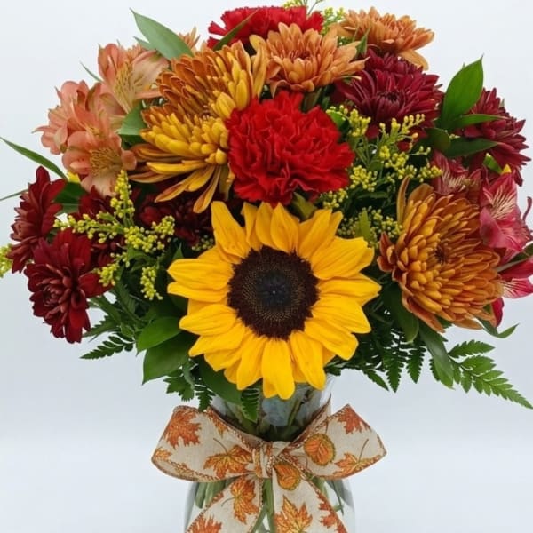 Bouquet of sunflowers, chrysanthemums, and a ribbon-tied vase
