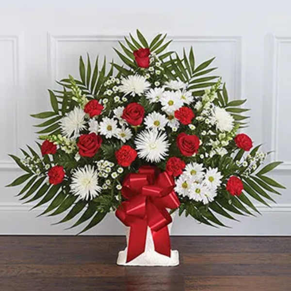 Standing floral spray with red roses, white daisies, and a red bow