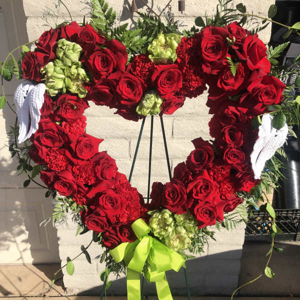 Heart-shaped red rose wreath with white angel wings and a lime ribbon