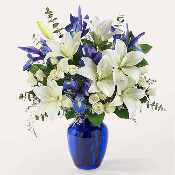 White lilies and blue irises in a cobalt vase