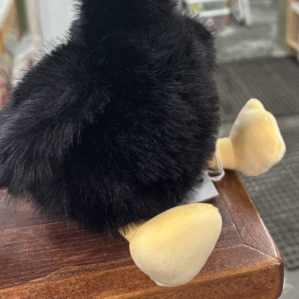 Black plush duck with a yellow beak and feet