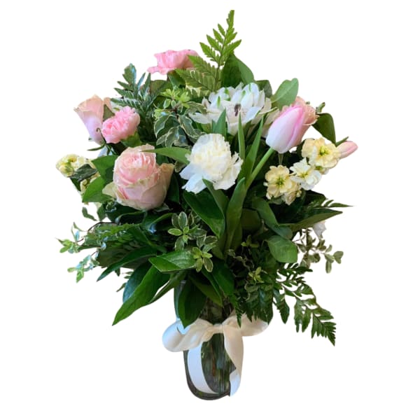 Pink and white bouquet in a clear glass vase with a white ribbon