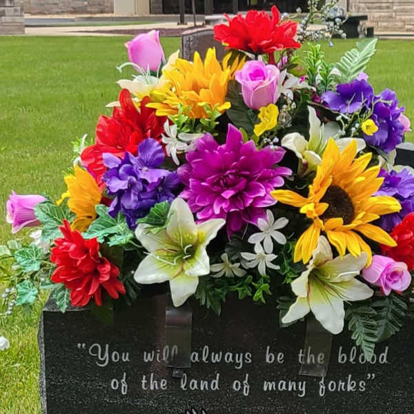Colorful floral arrangement on a gravestone in a cemetery